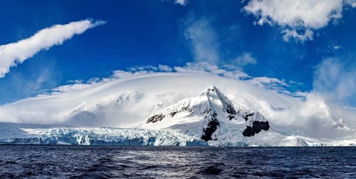 Panoramic view of impressive snow-capped mountains under dramatic clouds, The landscape in the
