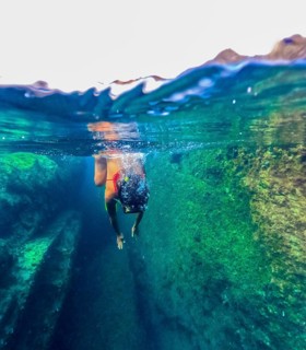 A female swimmer explores the clear natural pools of Tindaya Beach in Fuerteventura, Canary