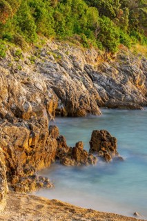 Crystal clear and turquoise water on the beach of Ustrine Bay on a sunny day at sunset on the