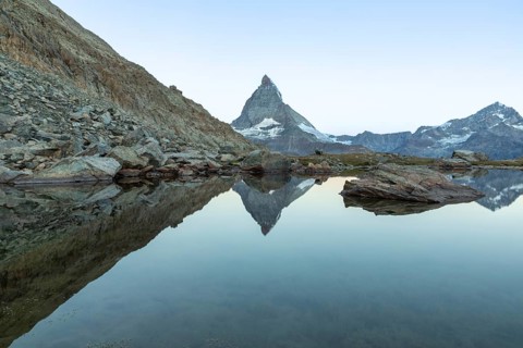 A stunning view of the iconic Matterhorn mountain, reflected perfectly in the serene waters of an