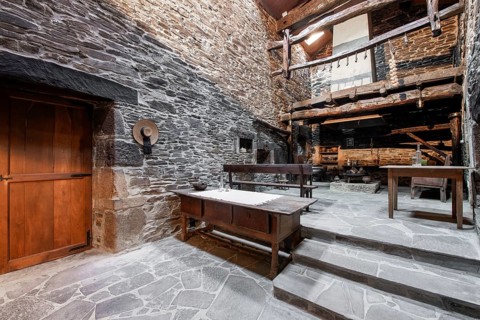 An authentic rustic kitchen featuring stone walls and wooden beams in a historical country house in
