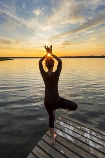 Woman practicing standing posture Vrikshasana, Tree Pose, one legged balancing asana of the