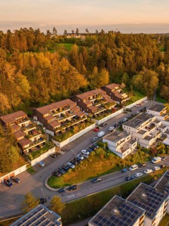 Terraced houses and residential buildings along a road, embedded in a wooded landscape, Nagold,