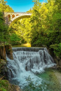 Stunning waterfall cascading beneath a stone bridge in the picturesque vintgar gorge near bled,