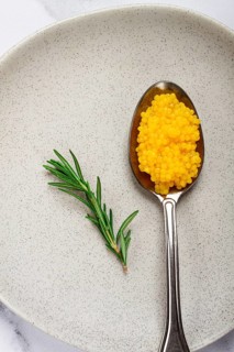 Yuzu caviar is pearly, on a spoon, top view, light background, no people