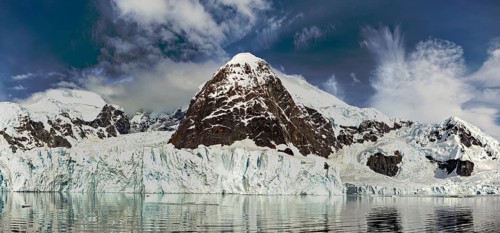 Impressive glacier and mountain landscape under a partly cloudy sky, radiating tranquillity and