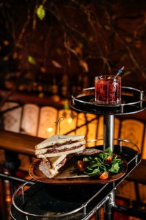 A delectable club sandwich with veal cheeks and cheese, paired with a refreshing Negroni cocktail.
