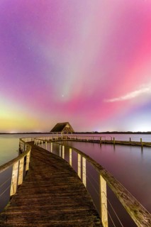 Wooden jetty and Northern Lights, Aurora borealis, polar lights over Lake Hemmelsdorf,