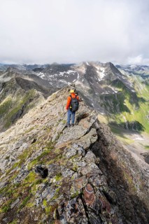 Mountaineer on a steep rocky ridge, on the summit of the Lasörling, Lasörling Group, Hohe Tauern