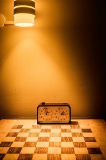 An inviting scene in Swedish Lapland featuring a chessboard and clock bathed in a warm glow from a