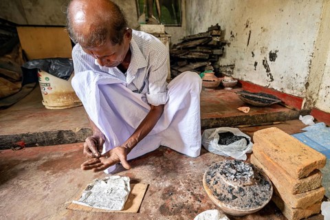 A man is busy with coal and a newspaper clipping in a quiet workshop, a man is burning sapphires in