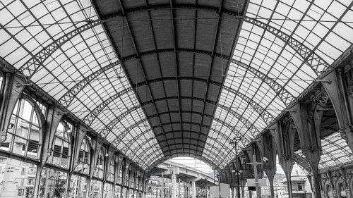 Black and white photo of the grand interior of a historic railway station in Nice, France,