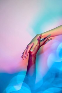 A close-up image of two multiethnic hands reaching towards each other in a gesture of unity and