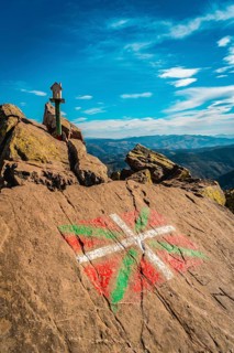 The flag of the Basque country and a figure of a house above Mount Adarra in Guipuzcoa one winter