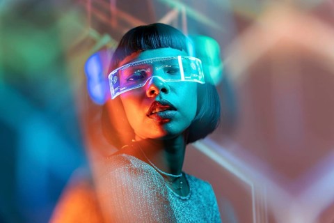 A Latin woman is deeply immersed in a virtual reality experience, wearing sleek VR glasses. The