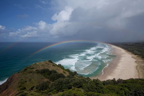 Tallow Beach bay with rainbow, lookout Byron Bay lighthouse, New South Wales, Australia
