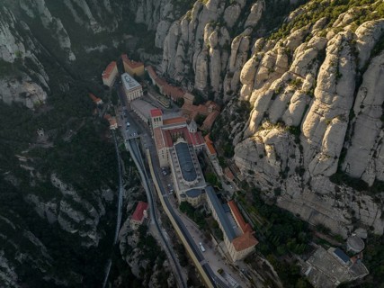 An aerial view of the Montserrat Abbey in Catalonia, Spain, showcases its unique placement amidst
