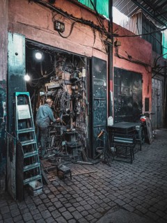 Small, dark workshop full of cables and metal in the Medina with craftsmen at work, atmospheric