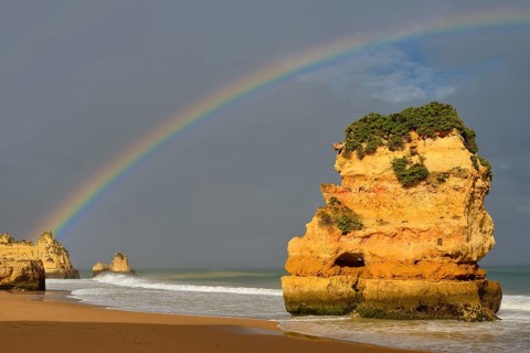 Rocks on beach with rainbow, Praia Dona Ana, Lagos, Algarve, Portugal