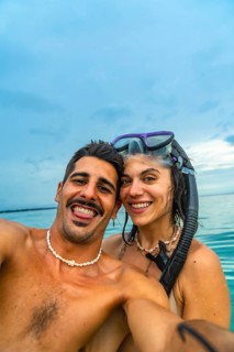 Couple taking a selfie with snorkeling gear in the ocean at white beach, cebu island, philippines,
