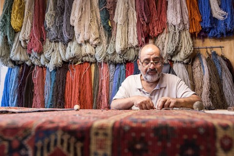 An Iranian master skillfully restores rare carpets in his well-equipped workshop in Salzburg,