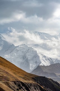 Dramatic mountain landscape, mountain valley, behind glaciated and snow-covered mountain peak Pik