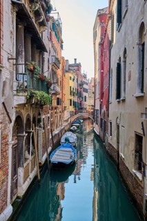 View on a waterway with boats lying in the water in Venice on a sunny day in winter, Italy