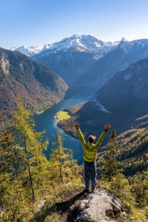 Mountaineer stretches his arms in the air, viewpoint Archenkanzel, panoramic view of the Königssee,