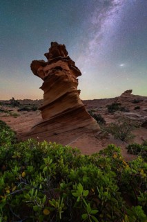 A stunning rock formation stands tall against a backdrop of a starry night sky in Coyote Buttes,