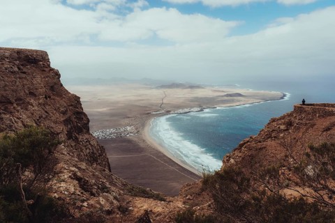 A stunning view of Lanzarote's rugged cliffs and expansive coastline, with waves crashing against