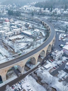 Snowy town with a bridge and cars in a winter landscape seen from the air, Nagold, Black Forest,