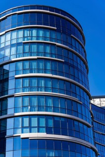 A stunning example of modern architecture featuring a curved glass facade with visible concrete and