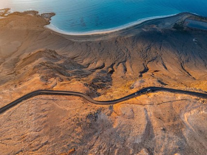 Road on cliffs in evening light, steep cliffs on the coast near Mirador del Porrito, aerial view,