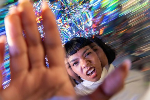 A futuristic Latin woman engages with the vibrant and dynamic digital world of the metaverse,