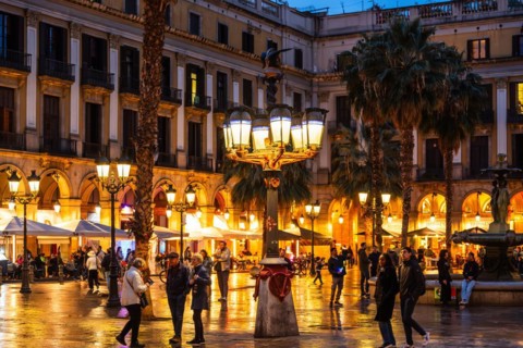 Nightlife at Plaça Reial, lanterns by Gaudi in the historic centre of Barcelona, Spain