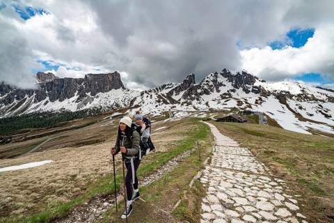 A mother and her young son enjoy a hike at Passo Giau in the Dolomites, Italy. They walk along a