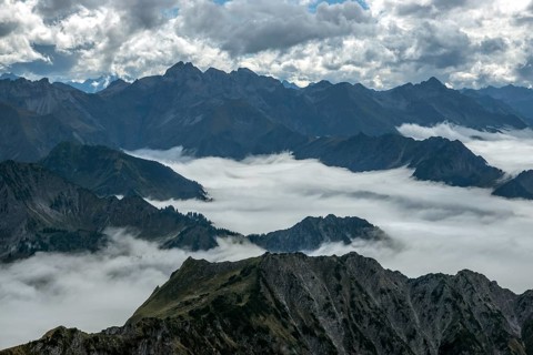 View from the Nebelhorn summit to mountains of the Allgäu Alps, mountains rising from fog in the