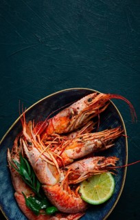 Langoustines, Australian, freshly frozen on ice, top view, lime and greens