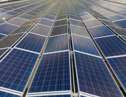 Aerial photo of expansive solar panels in Switzerland, capturing renewable energy under a clear sky