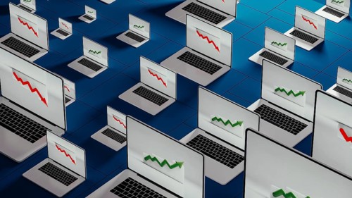Laptops in a modern office show fluctuating stock trends, reflecting the dynamic nature of