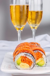 Delicious sushi rolls with salmon, avocado, and omelette are elegantly displayed on a plate,