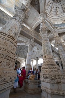Indian woman praying between the white marble pillars in the Adinath temple in Ranakpur, Jain