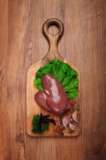 Raw pork kidneys, on a chopping board, close-up, top view, no people