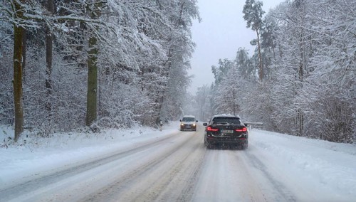 Cars on winter road in snowy forest, Erlangen, Middle Franconia, Bavaria, Germany