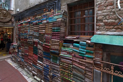 Stacked books on a wall after flood damage in a bookstore, Venice, Veneto, Italy