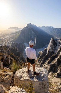 A man stands on a rocky peak at Eagle's Nest in Monterrey, Mexico, taking in the breathtaking view