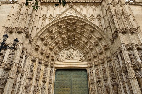 Elaborately decorated Gothic entrance door with detailed architectural elements, Seville,