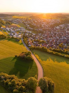 View of a village and a road surrounded by fields and trees at sunset, Gechingen, Black Forest,
