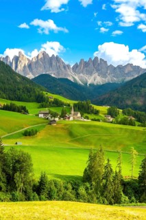 Green meadows and santa maddalena church under the odle mountain group in the italian dolomites