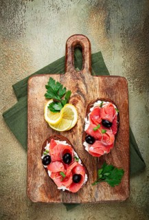 Sandwiches with cream cheese, chum salmon, cold smoked, grain bread, on a cutting board, top view,